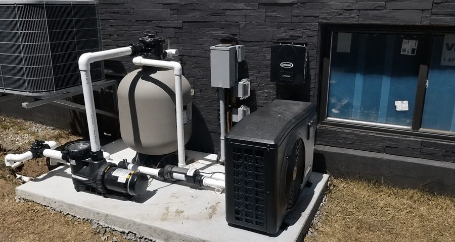 Filtre, pompe et thermopompe de piscine raccordés avec boîtiers de protection